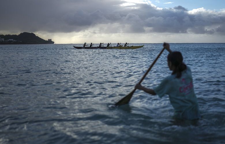 Chamorro students paddling in traditional outrigger canoes at Tumon Bay, in Guam on Feb. 20, 2023. The U.S. military is increasing its presence on Guam just as the island’s Chamorro people are trying to strengthen their Indigenous bonds. (Chang W. Lee/The New York Times) XNYT113 XNYT113