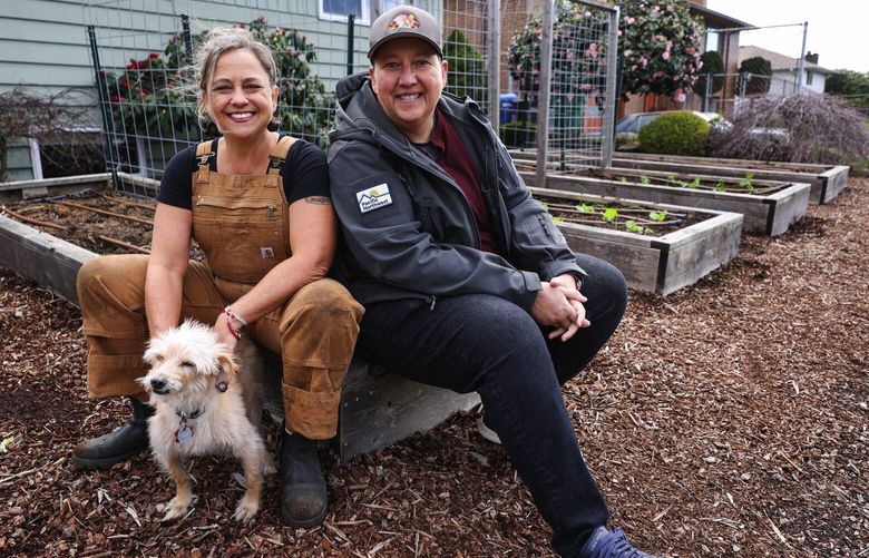 Heather Weiner, left,  and her wife, Carma Clark met in a P-Patch, and their mutual interest led to a garden their share with their community.  They are shown in their garden with dog Blondie. 223462