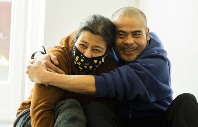 Phuong Duong holds tight Marie Dawson in his new apartment in the Central District on April 5, 2023. Duong and Dawson camped out at “The Jungle,” an infamous homeless encampment located under the I-5 bridge near Dearborn Street.