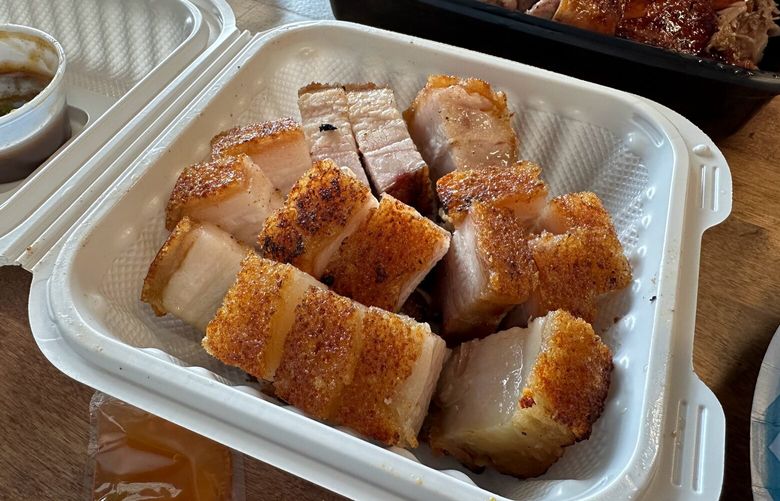 The roast pork at Issaquah’s Famous Kitchen features a crackly crust floating atop an unctuous layer of pork fat and belly. (Jackie Varriano / The Seattle Times)