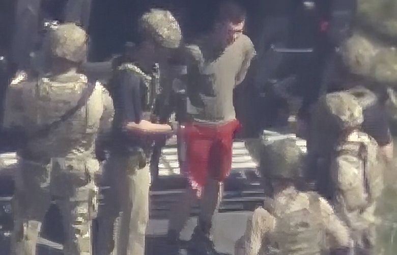 This image made from video provided by WCVB-TV, shows Jack Teixeira, in T-shirt and shorts, being taken into custody by armed tactical agents on Thursday, April 13, 2023, in Dighton, Mass. (WCVB-TV via AP) WX502 WX502