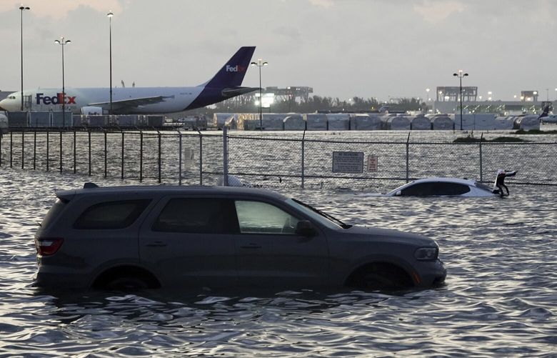 FILE – Flooding lingers at Fort Lauderdale-Hollywood International Airport on April 13, 2023, after heavy rain pounded South Florida. Over 25 inches of rain fell in South Florida since Monday, causing widespread flooding. (Joe Cavaretta /South Florida Sun-Sentinel via AP) FLLAU303 FLLAU303