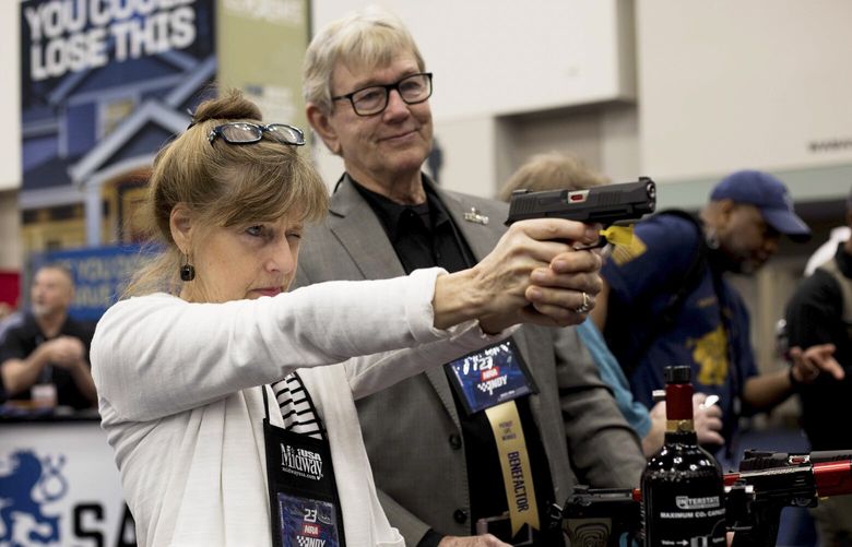 An attendee checks out a handgun at a vendor’s booth during the National Rifle Association’s annual convention in Indianapolis, April 14, 2023. Some of the most talked about current and potential Republican presidential candidates will address the convention on Friday. (Kaiti Sullivan/The New York Times)