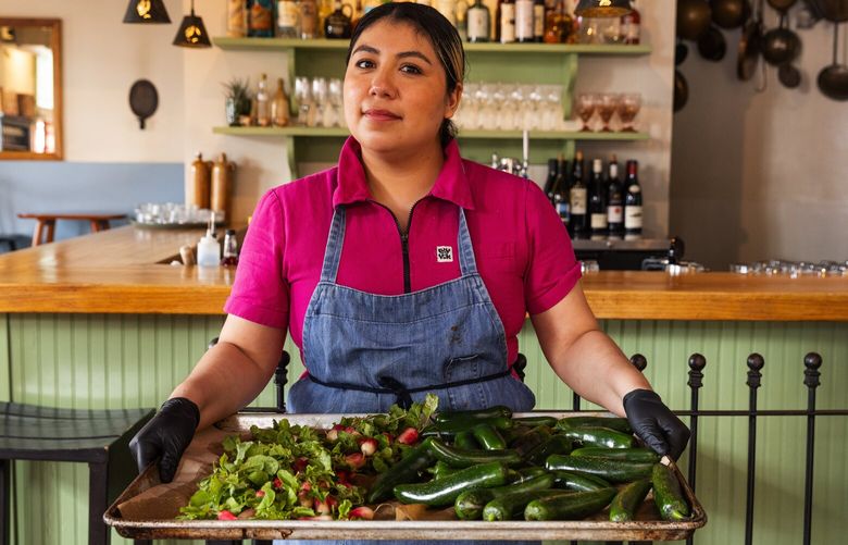 Janet Becerra’s Pancita is a concept pop-up at Pair where Mexican food is made from scratch, Thursday, March 30, 2023 in Northeast Seattle. Pictured: Janet Becerra holds a tray of fresh peppers and radishes for her salsas and sikil pak pepita dip.