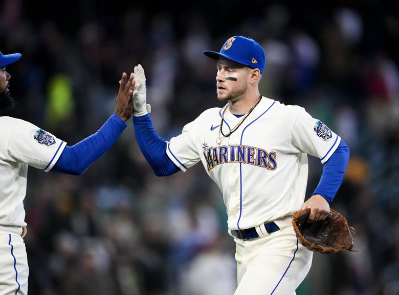 Seattle Mariners catcher Cal Raleigh, left, and relief pitcher Paul Sewald  celebrate after a baseball game