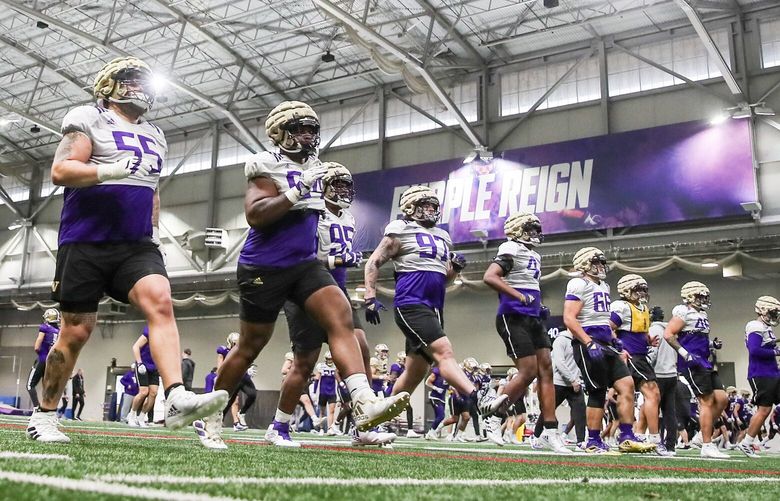Huskies work their way through warm-ups Friday morning during spring practice at the Dempsey Indoor Center in Seattle, Washington on March 10, 2023.