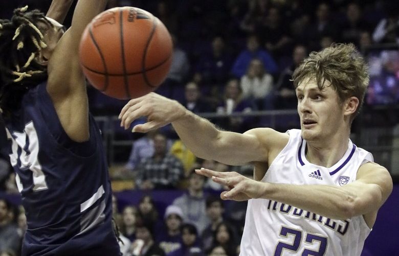 Washington Huskies guard Cole Bajema makes a pass with Washington Huskies guard Noah Williams defending Friday evening at Alaska Airlines Arena in Seattle, Washington on November 11, 2022. The Huskies are down 28-34 at the half.