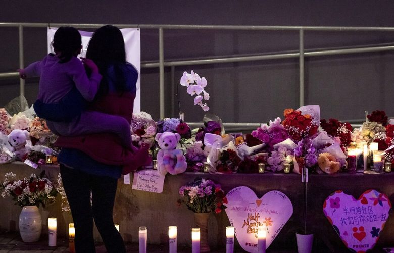 FILE – Elyane Stefanick holds her daughter Amara, 7, at a growing memorial for victims of Monday’s mass shooting in Half Moon Bay, Calif., on Wednesday, Jan. 25, 2023. Several memorials have been left in town and at the sites where the farmworkers were killed. The U.S. is setting a record pace for mass killings in 2023, replaying the horror in a deadly loop roughly once a week so far this year. The bloodshed overall represents just a fraction of the deadly violence that occurs in the U.S. annually. (Carlos Avila Gonzalez/San Francisco Chronicle via AP, File) CAFRA202 CAFRA202