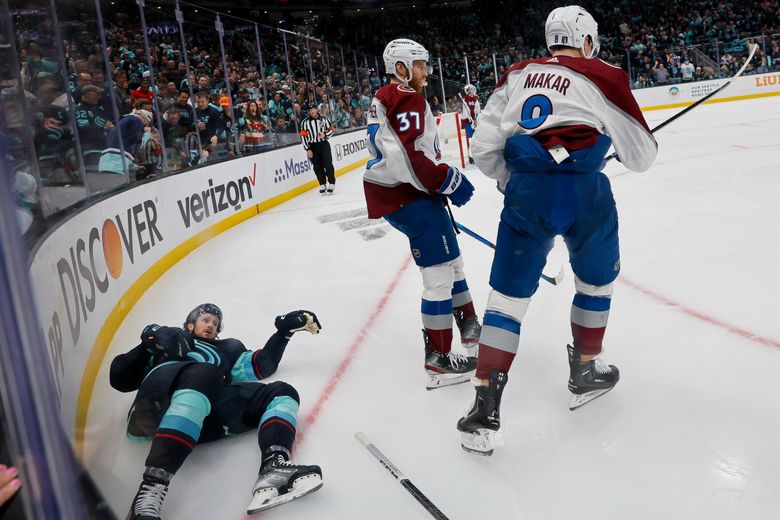 Seattle Kraken left wing Jared McCann lays stunned on the ice after taking a hit from Colorado Avalanche defenseman Cale Makar during the first period. Makar would get a two-minute interference penalty.  (Jennifer Buchanan / The Seattle Times)