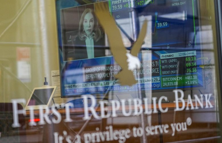 FILE – A television screen displaying financial news, including the stock price of First Republic Bank, is seen inside one of the bank’s branches in New York’s Financial District, on March 16, 2023. Customers of the bank pulled more than $100 billion in deposits out of the bank during the March crisis, as fears swirled that it could be the third bank to fail after the collapse of Silicon Valley Bank and Signature Bank. (AP Photo/Mary Altaffer, File) 