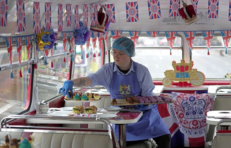 A staff member prepares afternoon tea for the new Coronation Tour Bus route, in London, Monday, April 24, 2023. The May 6 coronation is luring royal fans and far-flung visitors fascinated by the ceremonial spectacle — and drama — of the monarchy and eager to experience a piece of British history. Tour companies, shops and restaurants are rolling out the red carpet, whether it’s a decked-out bus tour of London’s top sights boasting high tea or merchandise running from regal to kitschy. (AP Photo/Kin Cheung) LLT512 LLT512