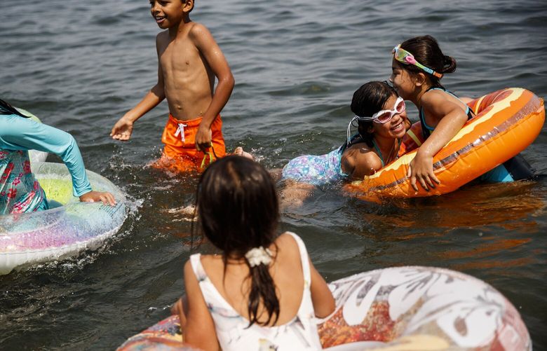 Seven-year-old Coco Hammond, right, jumps into her friend Sonya Gaubatz’s floating tube while they play at Pritchard Island Beach as temperatures reach in the high 80’s on Thursday, August 12, 2021 in Rainier Beach. An excessive heat warning is issued for Seattle area as the temperatures are expected to reach in the 90’s today.

*Ok from all the parents*

LO