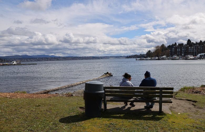 “When we first moved here all we heard was gun shots,” says Harry Kinoshita with his wife Pikake Kinoshita as they sit on a bench at Be-er Sheva Park in Rainier Beach in Seattle on Saturday, April 1, 2023. The couple moved here from Hawaii two years ago and never realized there was a beach. They said they heard gunfire and cars racing every single night, but its better now.