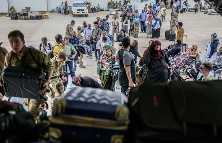 In this photo provided by the UK Ministry of Defence, British Nationals prepare to be evacuated onto a RAF aircraft at Wadi Seidna Air Base, in Sudan, Thursday, April 27, 2023. (PO Phot Arron Hoare/UK Ministry of Defence via AP) AMB822 AMB822