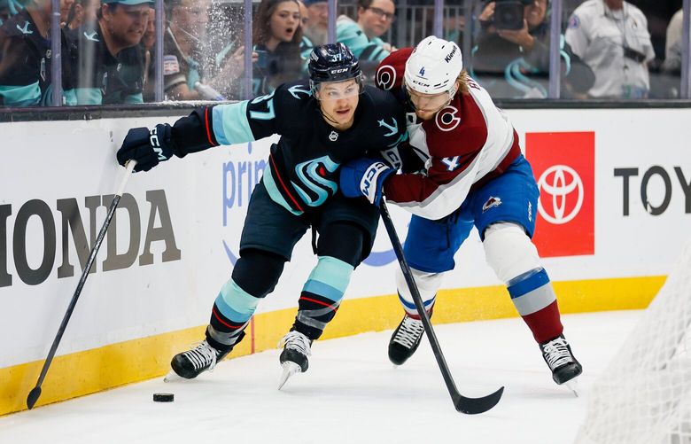 Seattle Kraken center Yanni Gourde keeps the puck away from Colorado Avalanche defenseman Bowen Byram as he skates behind the net during the first period. 223699