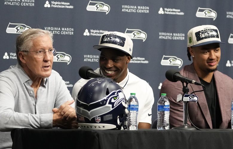 From left to right, Seattle Seahawks head coach Pete Carroll speaks as first-round NFL football draft picks Devon Witherspoon, a cornerback from Illinois, and Jaxon Smith-Njigba, a wide receiver from Ohio State, along with general manager John Schneider, listen during a news conference, Friday, April 28, 2023, at the team’s headquarters in Renton, Wash. (AP Photo/Lindsey Wasson) WALW115 WALW115