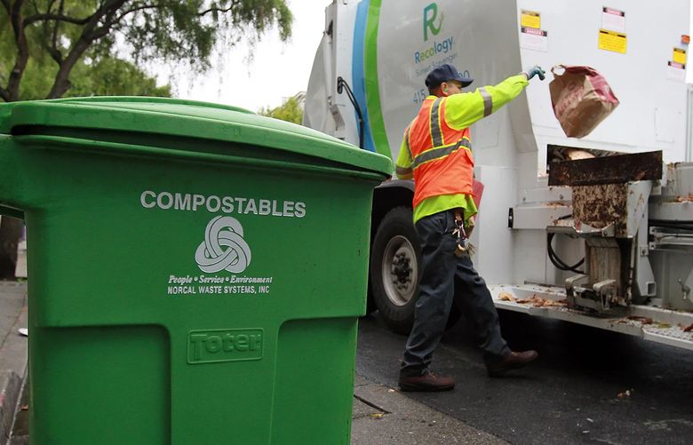 Recology worker Miguel Rojas throws a bag of compostable material into his truck on Dec. 10, 2010, in San Francisco, California. (Justin Sullivan/Getty Images North America/TNS)