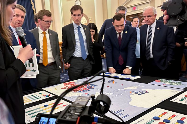 Lawmakers in a new House select committee on China gather for a tabletop war game exercise in the House Ways and Means Committee room on Wednesday, April 19, 2023, in Washington. Center of New American Security think tank defense program director Stacie Pettyjohn, left, Rep. Dusty Johnson, R-S.D., third from left, Rep. Jake Auchincloss, D-Mass., fourth from left, Rep. Haley Stevens, D-Mich., committee Chairman Mike Gallagher, R-Wis., second from right, and Rep. Carlos Gimenez, R-Fla. (AP Photo/Ellen Knickmeyer)