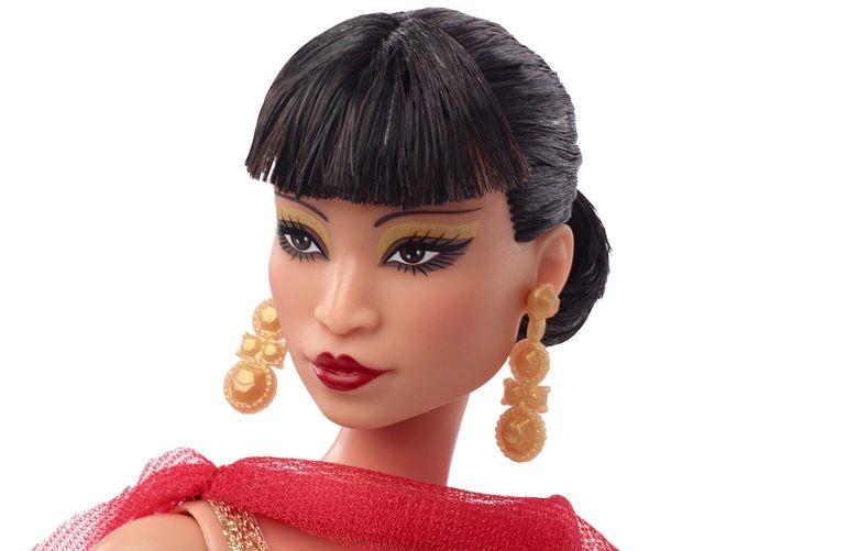 This image released by Mattel shows a Barbie doll in the image of Asian American Hollywood trailblazer Anna May Wong, part of their Inspiring Women Series. The doll is dressed in a frock inspired by Wong’s appearance in the  1934 movie “Limehouse Blues,” a red gown with a shiny golden dragon design and cape.  (Jason Tidwell/Mattel via AP) NYET103 NYET103