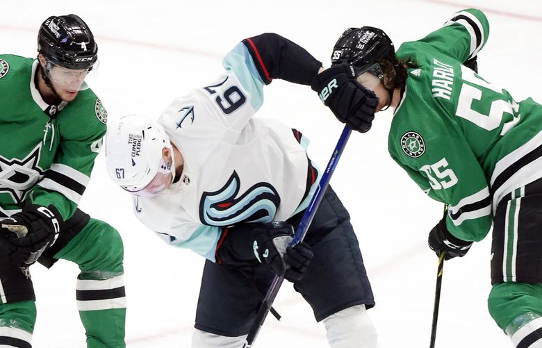Dallas Stars defenseman Miro Heiskanen (4) and Thomas Harley (55) attempt to steal the puck form Seattle Kraken center Morgan Geekie (67) during the second period of Game 1 of an NHL hockey Stanley Cup second-round playoff series in Dallas, May 2, 2023.