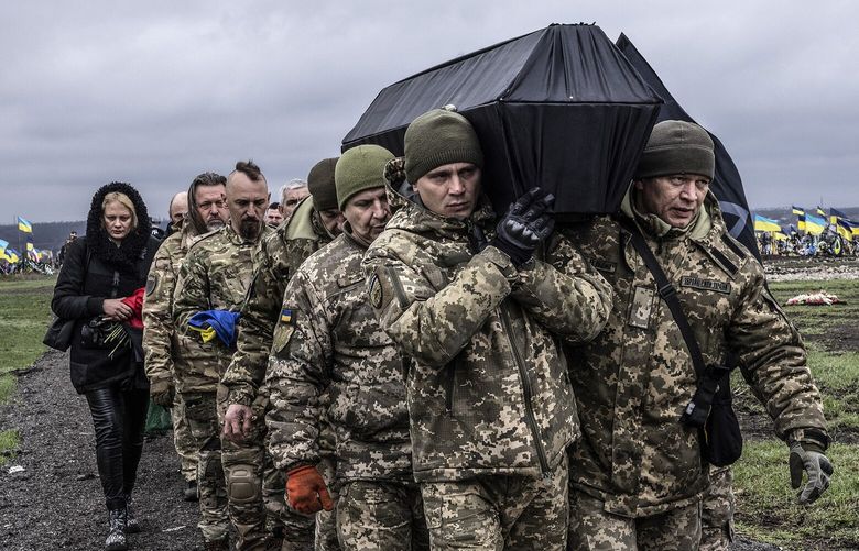 Ukrainian troops carry the coffin of a fellow soldier killed by mortar fire outside the city of Bakhmut, Ukraine, in early April 2023. MUST CREDIT: Photo for The Washington Post by Heidi Levine