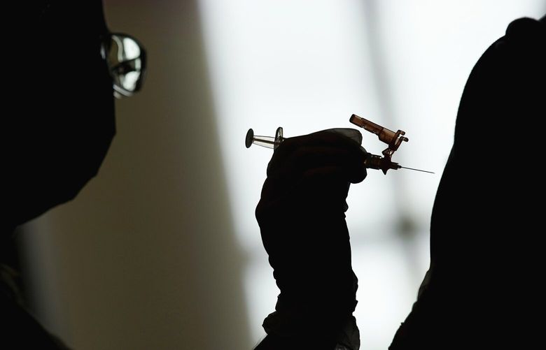FILE – In this April 26, 2021 file photo, a nursing student administers the Moderna COVID-19 vaccine at a vaccination center at UNLV, in Las Vegas. On Friday, April 21, 2023, The Associated Press reported on stories circulating online incorrectly claiming the COVID-19 mRNA vaccines from Pfizer and Moderna are no longer authorized in the U.S. because of safety concerns. (AP Photo/John Locher, File)