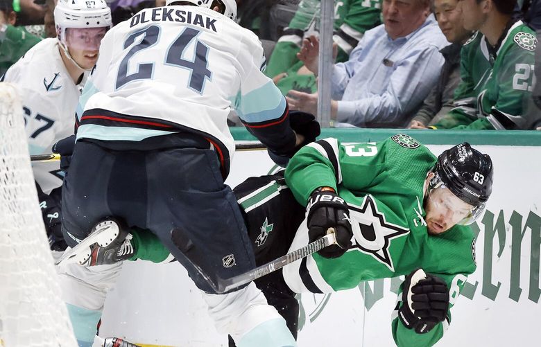 Dallas Stars right wing Evgenii Dadonov (63) is taken down by Seattle Kraken defenseman Jamie Oleksiak (24) behind the net during the first period of Game 2 of a Stanley Cup second-round playoff series in Dallas, May 2, 2023.