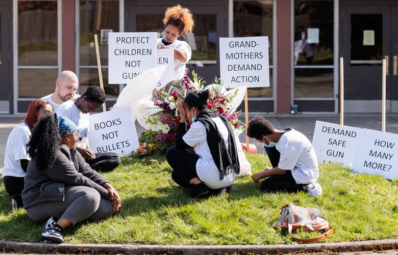 Mother Tsedale Woldemariam, center, attends a vigil outside Ingraham High School to honor her son Ebenezer Haile, 17, who was shot and killed at school last November, in Seattle on Wednesday April 26, 2023. 
 223683