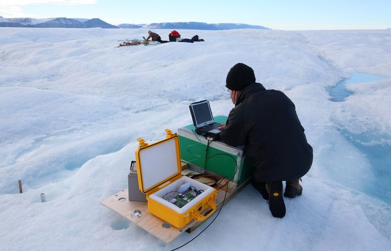 Scientists Andreas Muenchow, left in the distance, and Keith Nicholls, right, work on Petermann glacier in 2016. MUST CREDIT: Washington Post photo by Whitney Shefte.