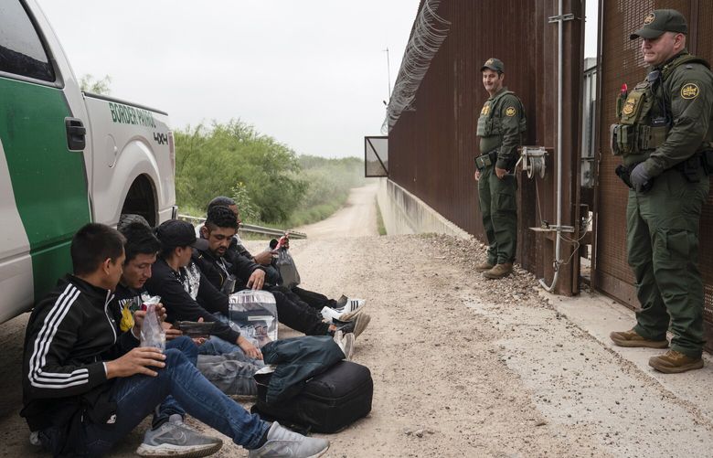 FILE – Colombian migrants that were trying to evade U.S. Border Patrol wait to be processed near the port of entry in Hidalgo, Texas, Thursday, May 4, 2023. A recent surge of migrants in the Brownsville area of the U.S.-Mexico border is highlighting immigration challenges as the U.S. prepares for the end of a policy linked to the coronavirus pandemic that allowed it to quickly expel many migrants. (AP Photo/Veronica G. Cardenas, File) WX226 WX226