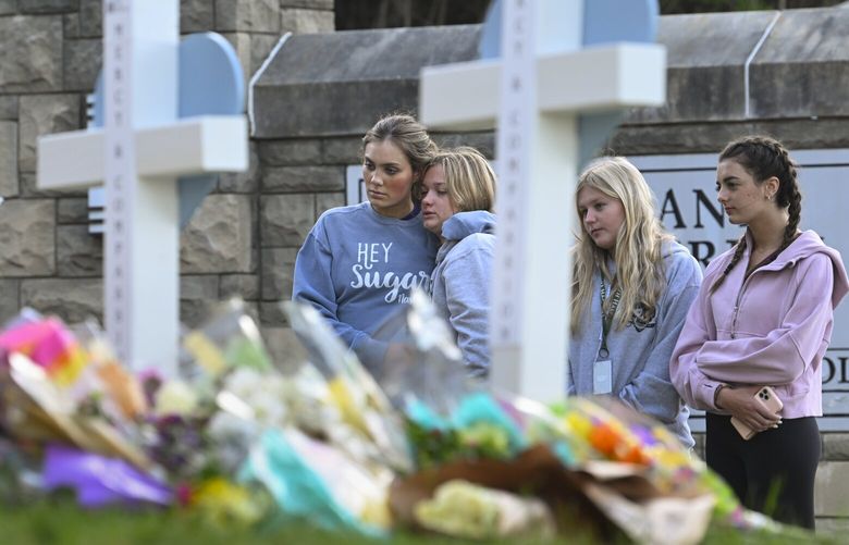 FILE – Students at a nearby school pay respects at a memorial for the people who were killed, at an entry to Covenant School, Tuesday, March 28, 2023, in Nashville, Tenn. More than 100 people have been killed in mass shootings thus far in 2023, an average of one mass killing a week. (AP Photo/John Amis, File) XKS504 XKS504
