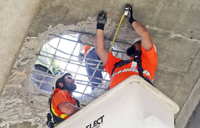 State highway workers inspect a gaping hole in the concrete from the underside of the on-ramp from West Seattle bridge to Northbound Highway 99, 
Wednesday, May 3, 2023. 223744