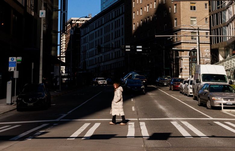 A pedestrian walks on 2nd Avenue in downtown Seattle Friday, Feb. 24, 202  223160