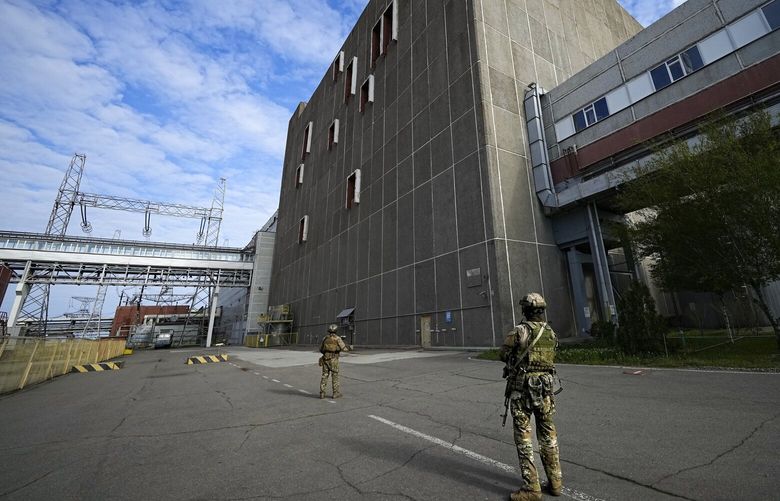 FILE – Russian servicemen guard an area of the Zaporizhzhia Nuclear Power Station, the largest nuclear power plant in Europe and among the 10 largest in the world in Enerhodar, Zaporizhzhia region, in territory under Russian military control, southeastern Ukraine, on May 1, 2022. Russia plans to relocate around 2,700 Ukrainian staff from Europe’s largest nuclear plant, Ukraine’s atomic energy company claimed Wednesday, May 10, 2023, warning of a potential “catastrophic lack of qualified personnel” at the Zaporizhzhia facility in Russia-occupied southern Ukraine. (AP Photo, File) ALP102 ALP102