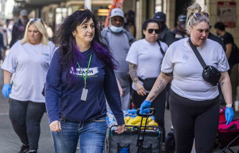 Mikel Kowalcyk, screening and outreach coordinator for REACH, center, works alongside with outreach workers from CoLEAD on Third Avenue in Seattle on April 28, 2023.