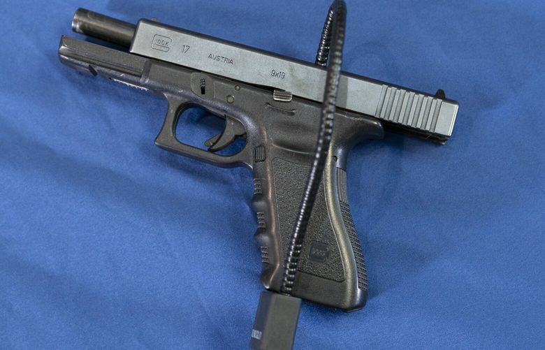 FILE – Displayed is a Glock 17 pistol fitted a with a cable style gun lock in Philadelphia, Wednesday, May 10, 2023. A federal judge in Virginia has ruled that a law banning licensed firearms dealers from selling handguns to young adults under 21 violates the Second Amendment and is unconstitutional. The ruling Wednesday, May 11, by U.S. District Court Judge Robert Payne in Richmond, if not overturned, would prevent dealers from selling handguns to 18- to 20-year-olds. (AP Photo/Matt Rourke, File) NYSS413 NYSS413