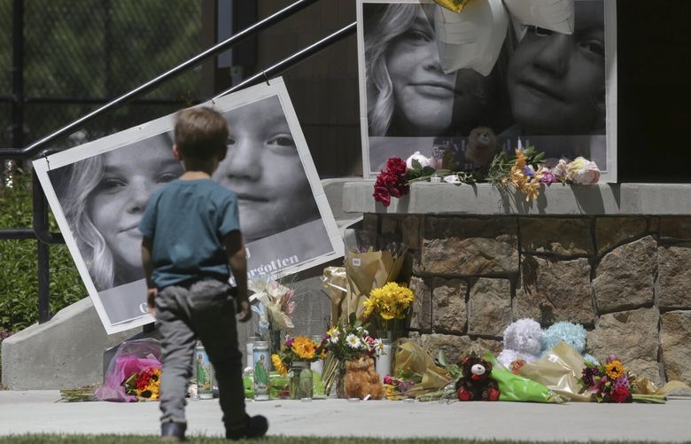 FILE – A boy looks at a memorial for Tylee Ryan and Joshua “JJ” Vallow in Rexburg, Idaho, on June 11, 2020. The sister of Tammy Daybell, who was killed in what prosecutors say was a doomsday-focused plot, told jurors Friday, April 28, 2023, that her sister’s funeral was held so quickly that some family members couldn’t attend. The testimony came in the triple murder trial of Lori Vallow Daybell, who is accused along with Chad Daybell in Tammy’s death and the deaths of Vallow Daybell’s two youngest children. (John Roark/The Idaho Post-Register via AP, File) IDIDF501 IDIDF501