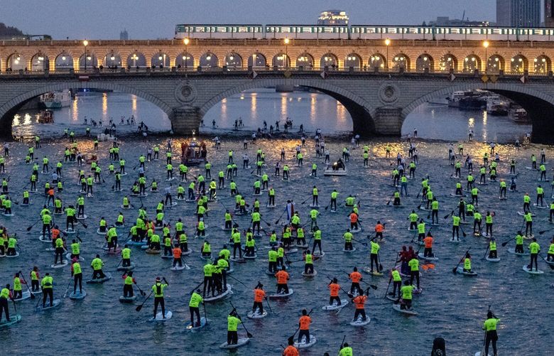— EMBARGO: NO ELECTRONIC DISTRIBUTION, WEB POSTING OR STREET SALES BEFORE 2:01 A.M. ET ON FRIDAY, MAY 12, 2023. NO EXCEPTIONS FOR ANY REASONS —Paddlers in the Seine in Paris, Dec. 4, 2022. In 2024, the river will serve as the venue for Olympic triathletes and distance swimmers. (James Hill/The New York Times) XNYT206 XNYT206