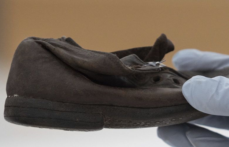 A worker holds a shoe that belonged to a child victim of the former Nazi German death camp Auschwitz-Birkenau at the conservation laboratory on the grounds of the camp in Oswiecim, Poland, Wednesday, May 10, 2023. Museum workers describe the children’s shoes as one of the most emotional testaments of the crimes carried out at Auschwitz, where Nazi German forces murdered 1.1 million people during World War II. (AP Photo/Michal Dyjuk) DYJ504 DYJ504