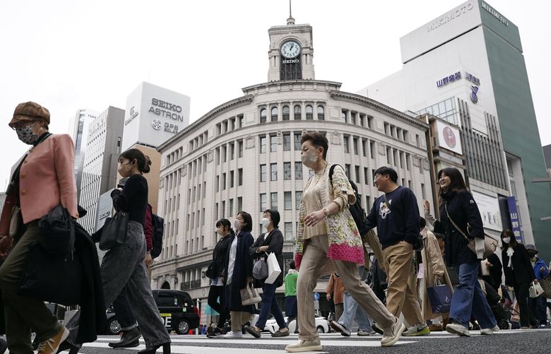 People walk at a pedestrian crossing in Ginza shopping district Friday, March 31, 2023, in Tokyo. Japan’s economy grew at an annual pace of 1.6% in the quarter through March as private demand rebounded after COVID-19-related restrictions were eased, according to data released Wednesday, May 17, 2023. (AP Photo/Eugene Hoshiko, File) 