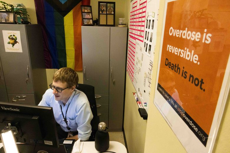 Dr. David Sapienza goes over patient information for the day with staff at the Downtown Seattle Public Health Center’s Pathways opioid-use treatment program on May 17. (Daniel Kim / The Seattle Times)