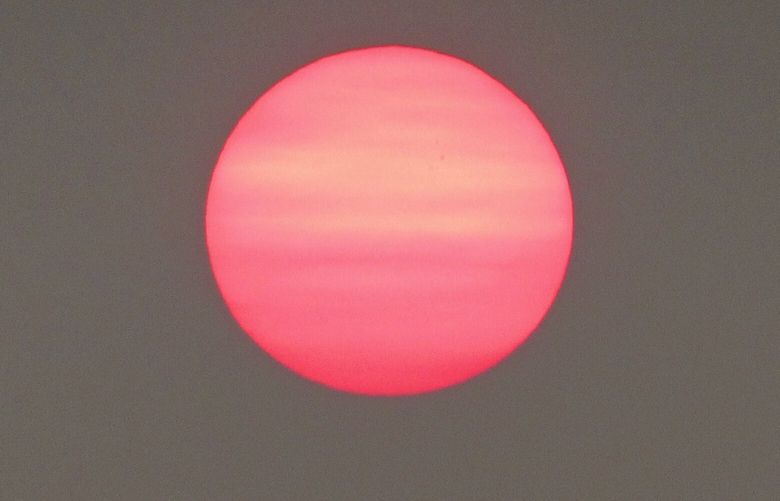 Haze blankets the sky creating a red sunrise as wildfire smoke arrives from Alberta Wednesday morning.