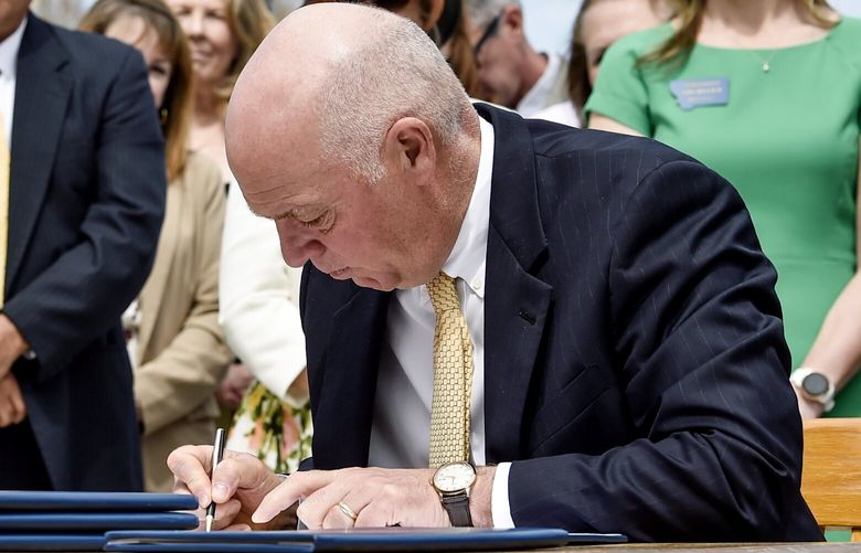 FILE – Gov. Greg Gianforte signs a suite of bills aimed at restricting access to abortion during a bill signing ceremony on the steps of the State Capitol, in Helena, Mont., on May 3, 2023. A judge on Thursday, May 18, 2023, granted Planned Parenthood of Montana’s request to temporarily block enforcement of a law that bans the abortion method most commonly used after 15 weeks of pregnancy until he can hear arguments from both sides at a hearing on Tuesday, May 23. (Thom Bridge/Independent Record via AP, File) MTHEL451 MTHEL451