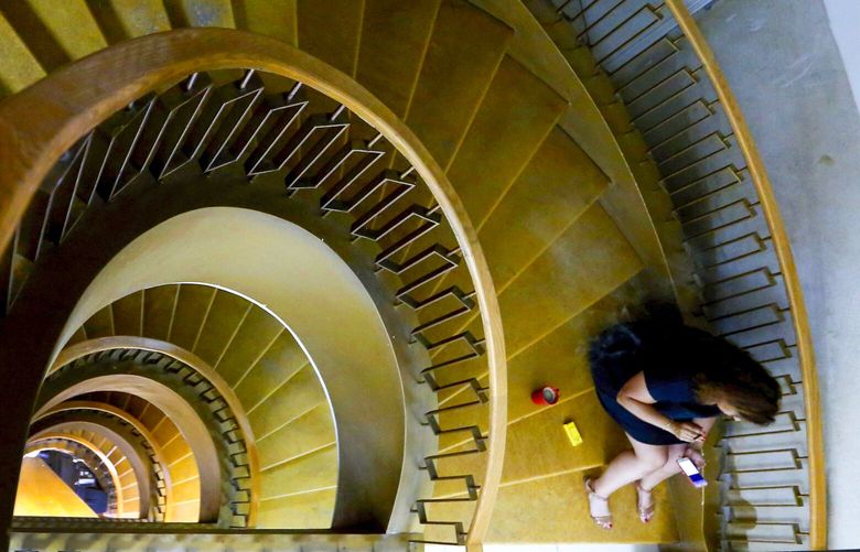 A woman uses her phone as she sits on stairs. (AP Photo/Hassan Ammar)