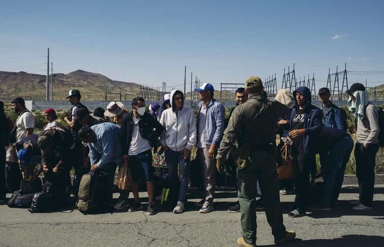 — EMBARGO: NO ELECTRONIC DISTRIBUTION, WEB POSTING OR STREET SALES BEFORE 3:01 A.M. ET ON TUESDAY, MAY 16, 2023. NO EXCEPTIONS FOR ANY REASONS — A U.S. Border Patrol agent lines up migrants who had waited for days to be processed at a detention center in Jacumba, Calif., May 14, 2023. Fears of chaos at the southern border eased as arrivals ebbed after an initial surge of about 10,000 migrants just hours before the Title 42 pandemic immigration restrictions expired. (Mark Abramson/The New York Times) XNYT180 XNYT180