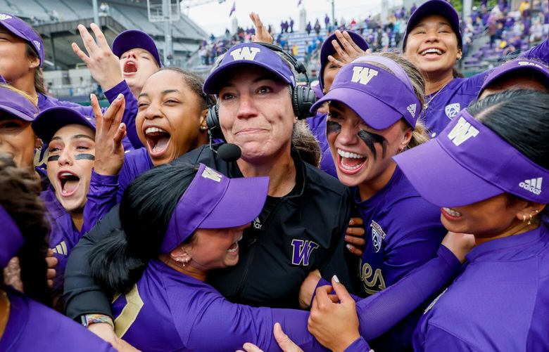 The Husky softball team mobs head coach Heather Tarr, in black, after Washington came back down six runs in the seventh inning to beat McNeese State 7-6. 223995