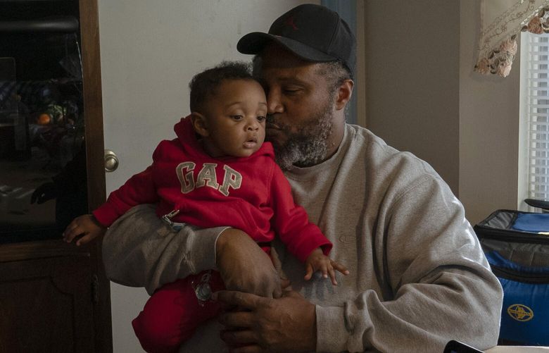 James Lyons kisses his grandson, Adrien Lyons, in the kitchen of his home in Birmingham, Ala., on Saturday, Feb. 5, 2022. (AP Photo/Wong Maye-E) NYWM517 NYWM517