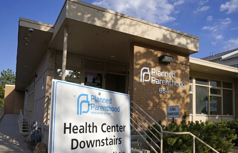 FILE – A sign stands outside Planned Parenthood of Utah on June 28, 2022, in Salt Lake City. Planned Parenthood is shifting funding to its state affiliates and cutting national office staff to reflect a changed landscape in both how abortion is provided and how battles over access are playing out. The group, a major provider of abortion and other health services and also an advocate for abortion access, told its staff on Monday, May 22, 2023, that layoff notices would go out in June and provided The Associated Press with an overview Tuesday. (AP Photo/Rick Bowmer, File) NYAB204 NYAB204