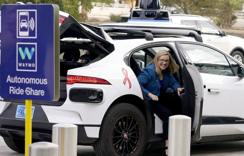 Phoenix Mayor Kate Gallego arrives in a Waymo self-driving vehicle in 2022, at the Sky Harbor International Airport Sky Train facility in Phoenix. Self-driving car pioneer Waymo announced May 4, 2023, that its robotaxis will be able to carry passengers through most of the Phoenix area for the first time. (AP Photo/Matt York, File) 