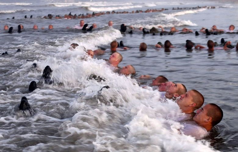 FILE – U.S. Navy SEAL candidates, participate in “surf immersion” during Basic Underwater Demolition/SEAL (BUD/S) training at the Naval Special Warfare (NSW) Center in Coronado, Calif., on May 4, 2020. The training program for Navy SEALs is plagued by widespread medical failures, poor oversight and the use of performance enhancing drugs that have increased the risk of injury and death to candidates seeking to become an elite commando, according to a highly critical new investigation triggered by the death of SEAL candidate Kyle Mullen. (MC1 Anthony Walker/U.S. Navy via AP, File) WX112 WX112